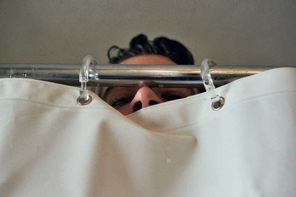 Matt's nose poking out from above a shower curtain.