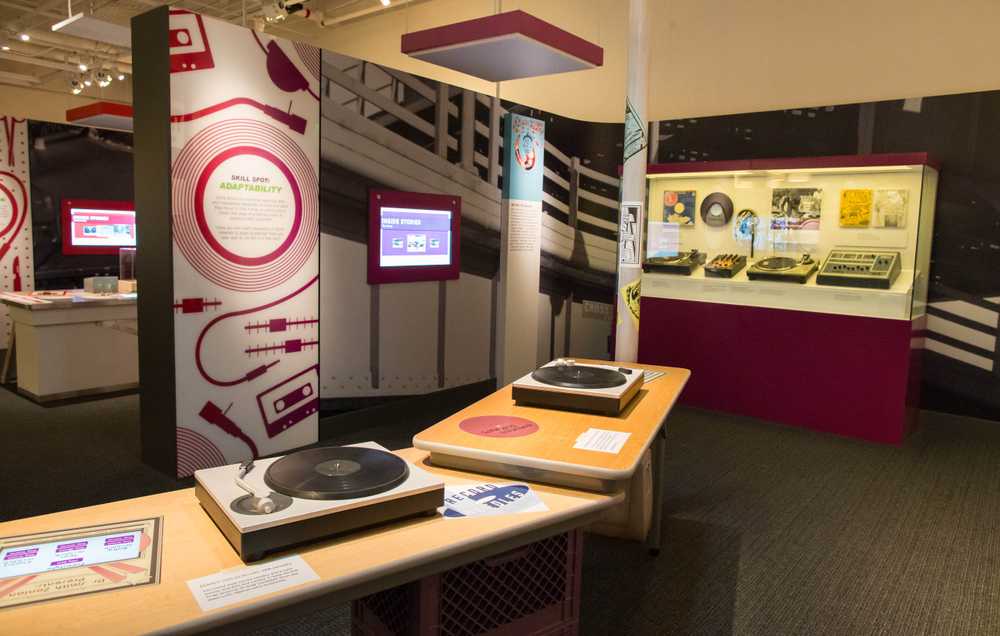 Two interactive devices themed to look like turntables sitting in the a museum gallery.