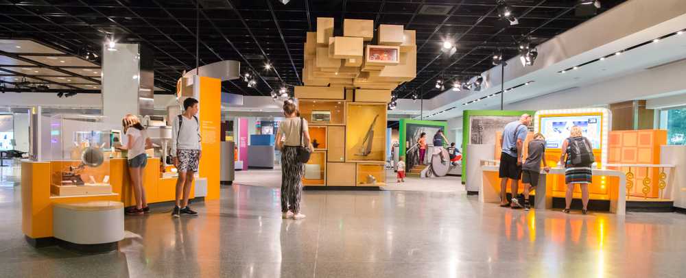 A museum exhibit featuring a large sculpture made of wooden display cases stacked together.